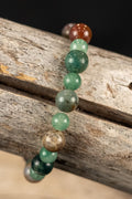 Beaded bracelet with green and brown beads on a wooden surface