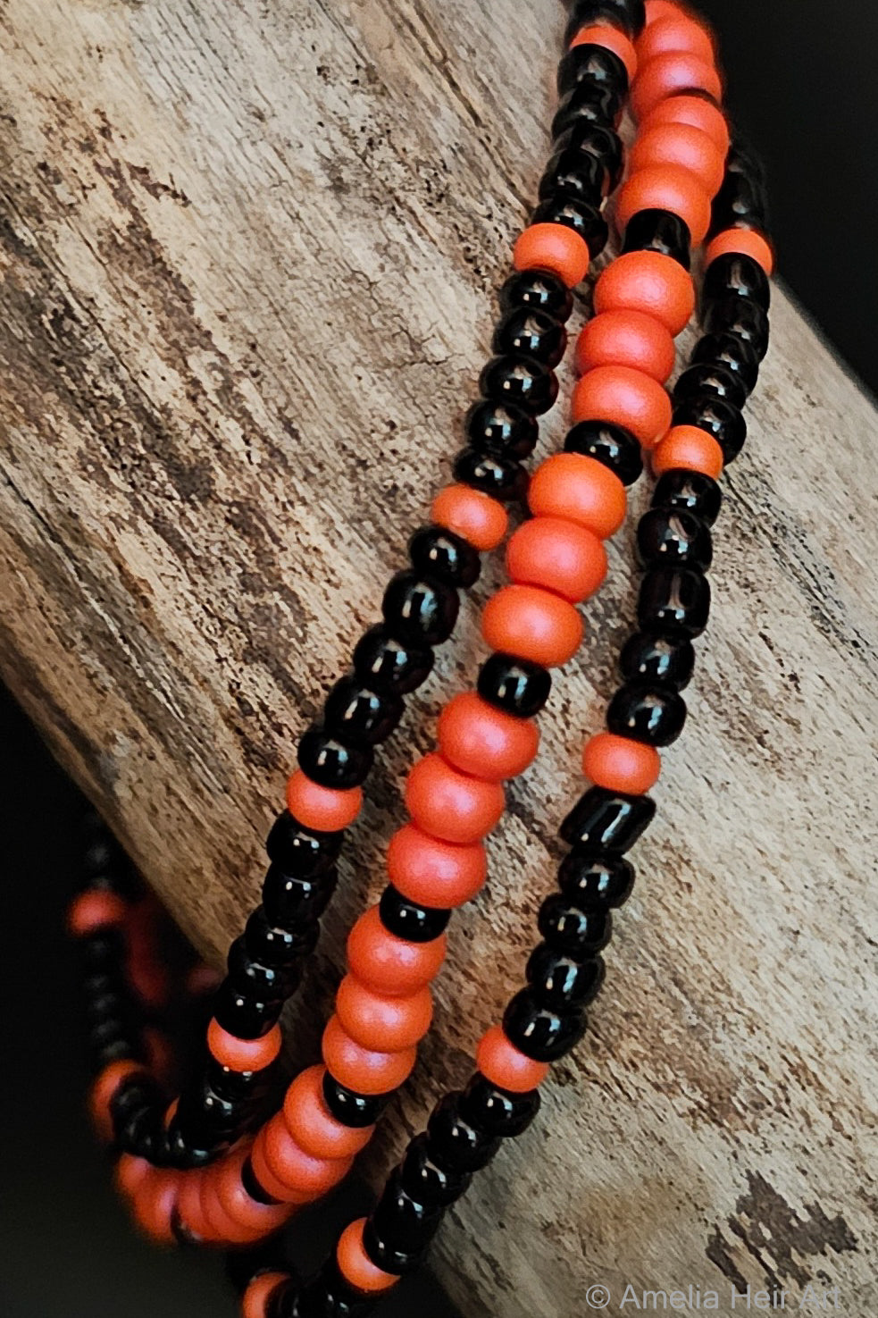 Black and pink beaded bracelets on a wooden surface