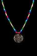 Necklace with colorful beads and a silver Celtic knot pendant on a black background
