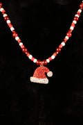 Necklace with red and white beads and a Santa hat pendant on a black background