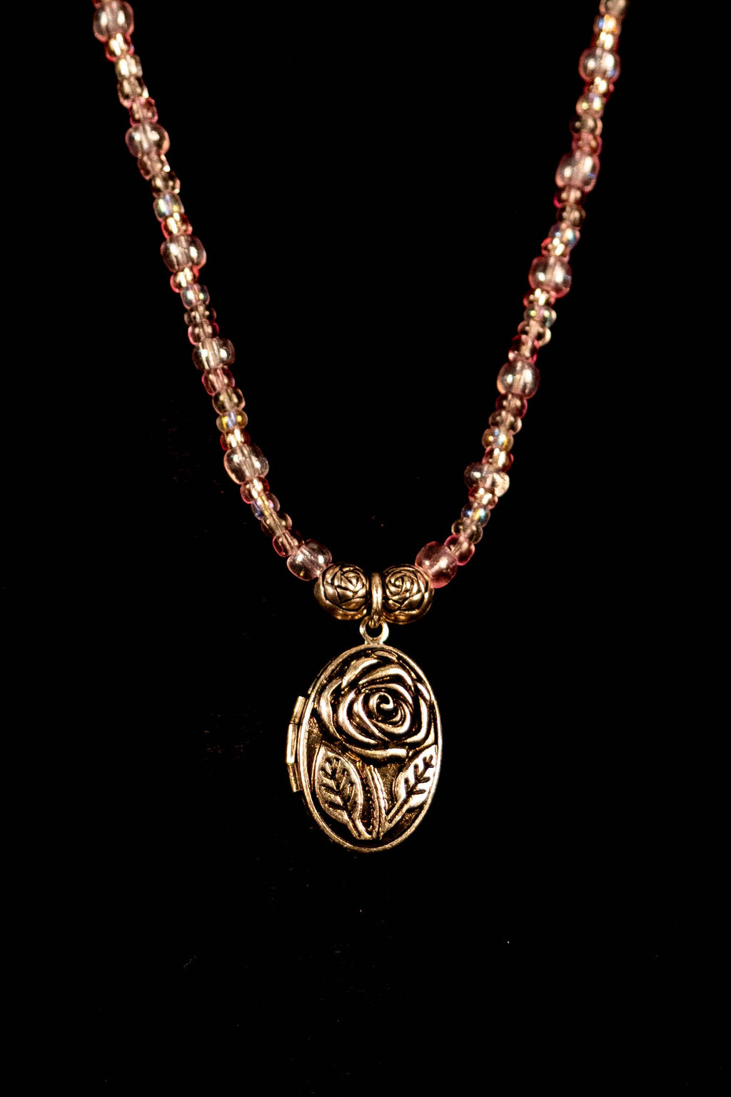Sarah handcrafted pink silver and clear beaded necklace with locket and rose charms on a black background — Amelia Heir Art
