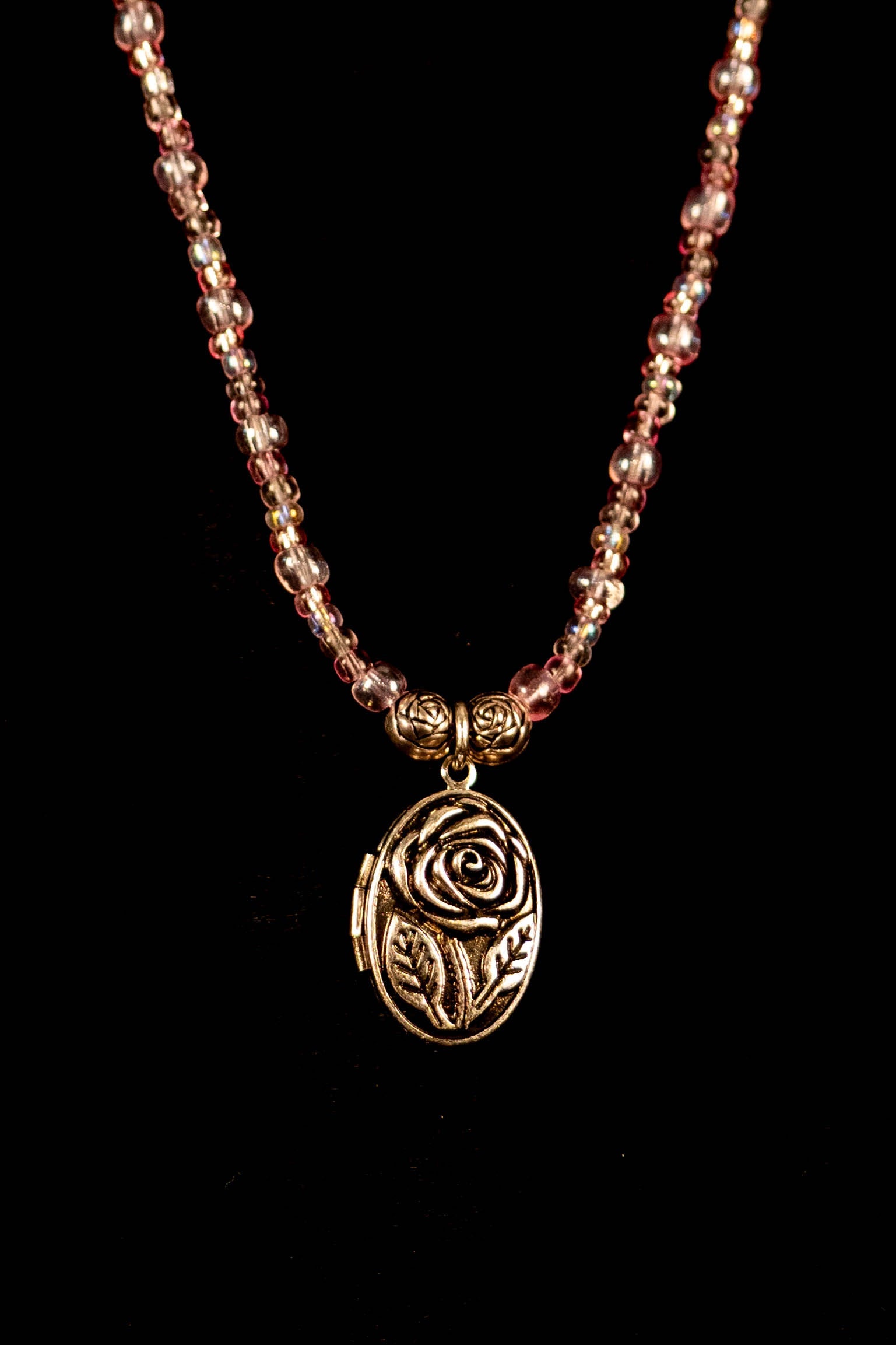Necklace with rose-shaped pendant on a black background