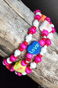 Colorful beaded bracelet with heart-shaped 'LOVE' charms on a wooden surface