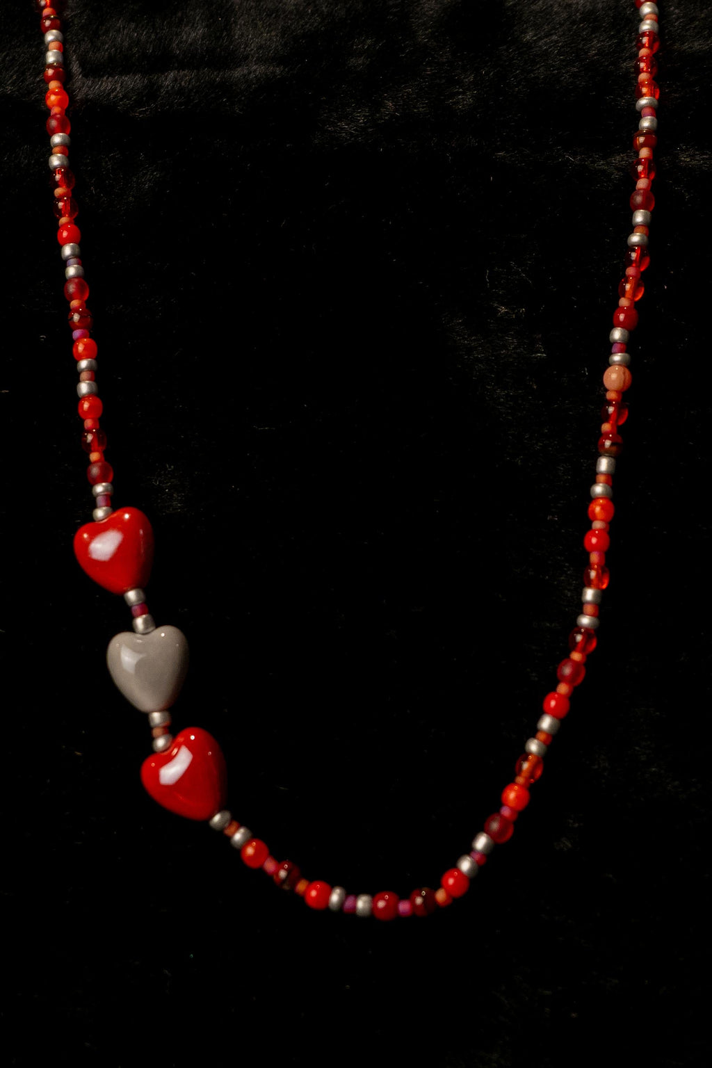 Smoochy handcrafted red gray and silver beaded necklace with heart charm on a black background — Amelia Heir Art