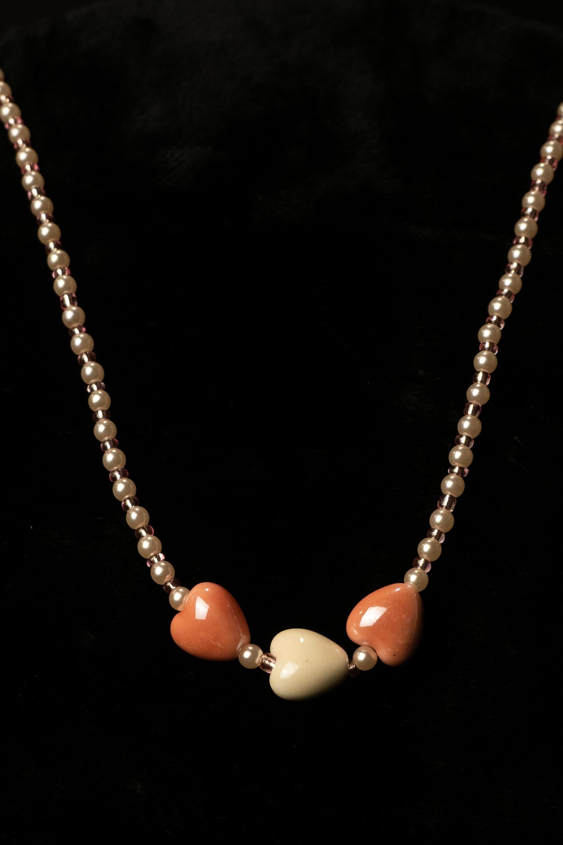 Necklace with heart-shaped beads on a black background