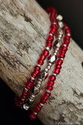 Red and silver beaded bracelets on a wooden surface