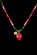 Necklace with colorful beads and a strawberry pendant on a black background