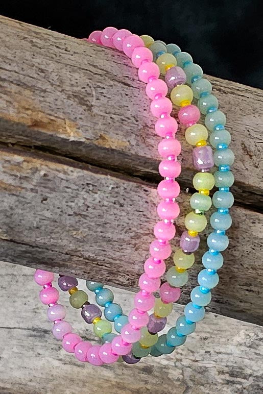 Set of colorful beaded bracelets on a wooden surface