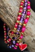 Colorful beaded bracelets with 'LOVE' and heart charms on a wooden surface.