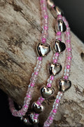 Three beaded bracelets with heart-shaped beads on a wooden surface