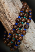 Wooden beads with blue and green accents on a wooden surface
