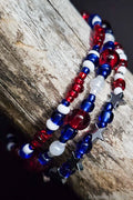 Red, white, and blue beaded bracelets with star accents on a wooden surface